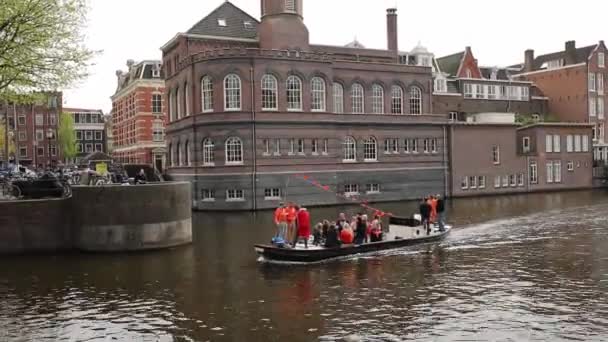 荷兰阿姆斯特丹 2018年4月28日 船上人员在荷兰阿姆斯特丹庆祝国王日 国王日是荷兰王国的国定假日 在阿姆斯特尔河运河 人们坐船 — 图库视频影像
