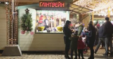 KIEV, UKRAINE 6 HAZİRAN 2018: İnsanlar Kiev 'deki Noel pazarından sıcak şarap satın alıyor. Kiev 'deki Sophia Meydanı' nda Noel ve yeni yılı kutluyoruz. İnsanlar meydanda yürüyor, hediyelik eşya ve sıcak şarap alıyor..