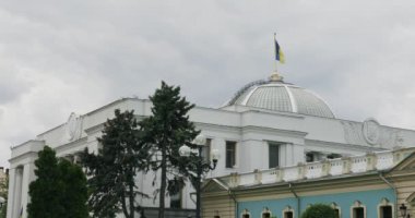 Kiev 'deki parlamento binasının tepesinde Ukrayna bayrağı. Verhovna Rada binası da anayasa meydanında yer almaktadır ve 1939 yılında mimar Volodymyr Zabolotniy tarafından inşa edilmiştir.. 