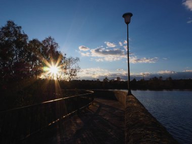 Köprü üzerinde gün batımında sokak lambası ve bulutlu mavi gökyüzü