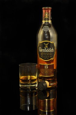 Glenfiddich Malt viskisi, siyah arka planda. Geyik vadisi. Viski, İskoçya 'nın önemli bir ihracat ürünüdür.