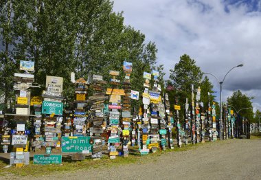 İşaret Postası Ormanı, Watson Gölü 'nün Alaska Otoyolu' ndaki ünlü cazibesidir. Dünyanın her yerinden gezginler işaretler getirip kutuplara astılar Watson Gölü, Yukon, Kanada