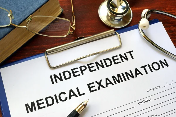Formulario de examen médico independiente (IME) sobre una mesa de madera . —  Fotos de Stock