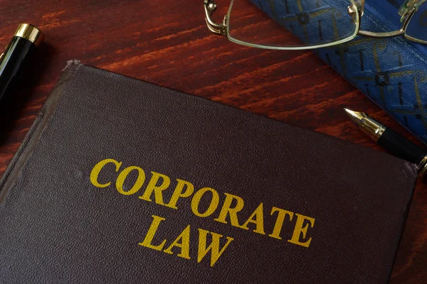 Kniha s názvem firemní zákonem na stůl. — Stock fotografie