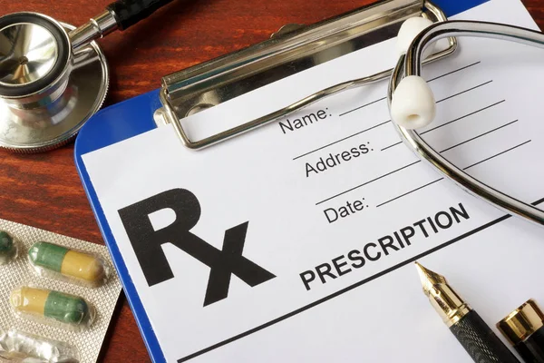 Modulo di prescrizione su un tavolo con stetoscopio e pillole . — Foto Stock