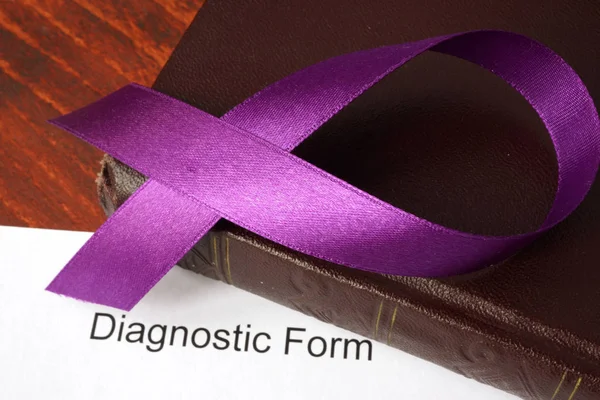 Pancreatic cancer diagnosis.  Awareness purple ribbon on a book. — Stock Photo, Image