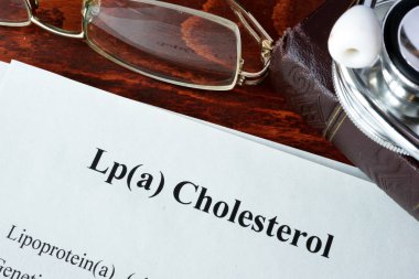Papers with words Lp(a) Cholesterol on a table. clipart
