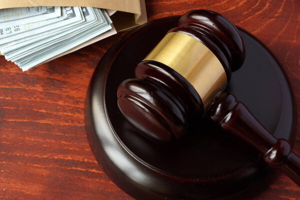 Corruption in a court concept. A gavel and money on a table.