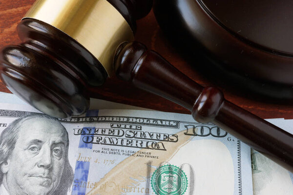 A gavel and currency on a table.