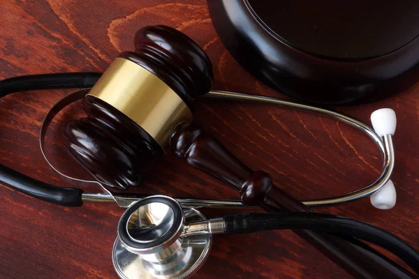 Gavel and stethoscope on a wooden surface. — Stock Photo, Image