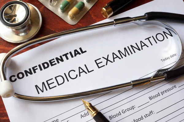 Conceito de confidencialidade médica. Formulário de exame médico em uma mesa . — Fotografia de Stock