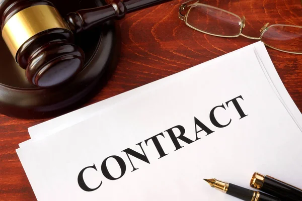 A contract and a gavel on a table.