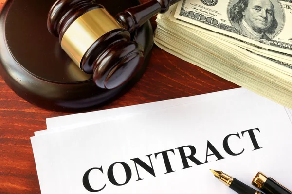 Contract, cash and gavel on a wooden surface. — Stock Photo, Image