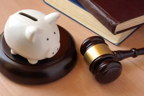 Piggy bank, gavel and books on a table. — Stock Photo, Image