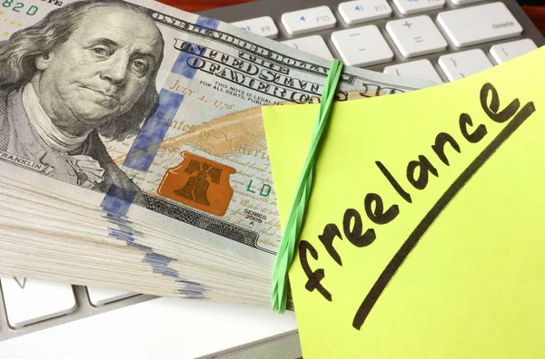 Papel com palavra Freelance, dinheiro e teclado . — Fotografia de Stock
