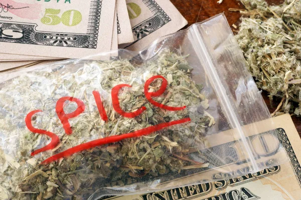 Zak van onkruid met teken Spice over een dollar biljetten. — Stockfoto