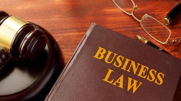 Book with title business law and gavel.