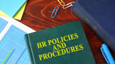 Book with title HR policies and procedures on a table. clipart