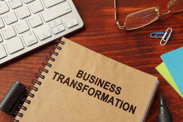 Boka med titeln business transformation på ett kontor. — Stockfoto