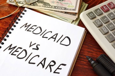 Medicaid vs Medicare written in a note. Health insurance concept. clipart