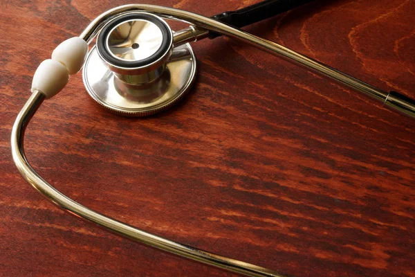 Health care background. Stethoscope on a wooden table. — Stock Photo, Image