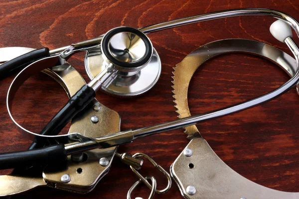 Medical negligence concept. Stethoscope and handcuffs. — Stock Photo, Image