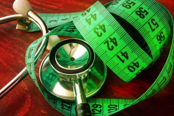 Concepto de pérdida de peso médica. Cinta métrica y estetoscopio . — Foto de Stock