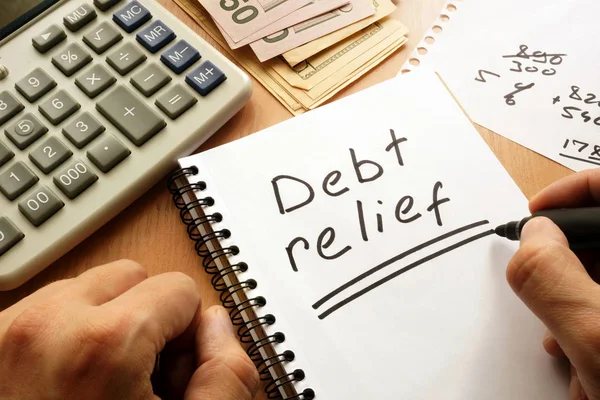 Note with words debt relief on a table. — Stock Photo, Image