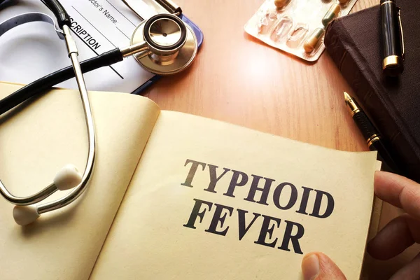 Livro com o título febre tifóide em uma mesa . — Fotografia de Stock