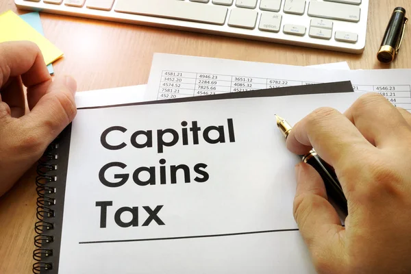 Hands holding documents with title capital gains tax CGT. — Stock Photo, Image