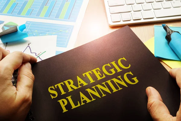 Manos sosteniendo documentos con título de planificación estratégica . — Foto de Stock