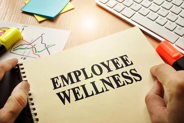 Hands holding documents with title Employee Wellness. — Stock Photo, Image