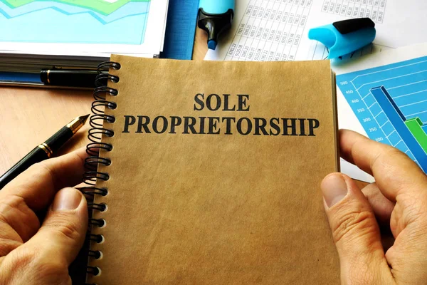Handen met boek met titel Sole proprietorship. — Stockfoto
