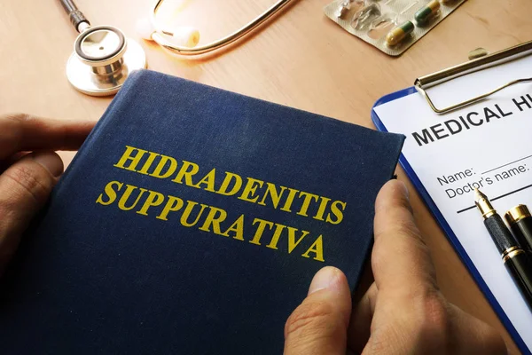 Boka med titeln Hidradenitis Suppurativa på ett bord. — Stockfoto