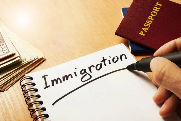 Hand is het schrijven van immigratie op een nota. — Stockfoto