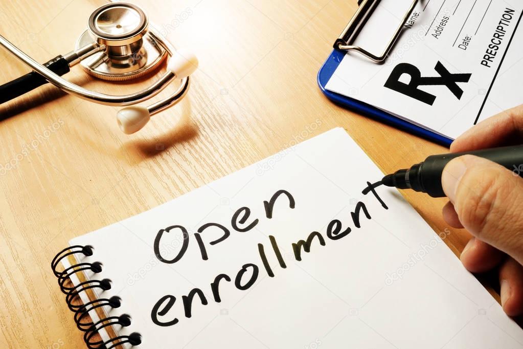 Open enrollment written on a note and medical stethoscope.
