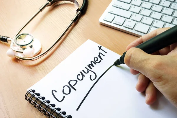 Handschrift teken copayment in een notitie. — Stockfoto