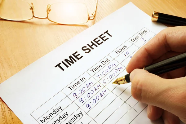 Records work hours in a time sheet. — Stock Photo, Image