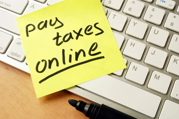 Memo stick with words pay taxes online. Stock Photo
