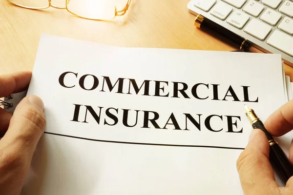 Formulario de seguro comercial sobre una mesa . — Foto de Stock
