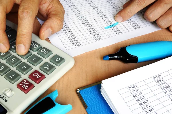 Bookkeeper using calculator to check the figures on the business report. Accounting and audit concept. — Stock Photo, Image