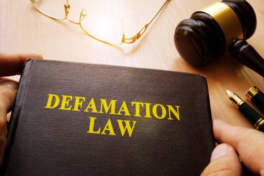 Defamation Law and gavel on a table. clipart