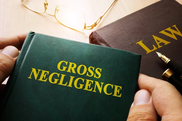 Man holding Gross Negligence book. — Stock Photo, Image