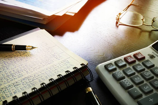 Office table with accounting book and financial report.