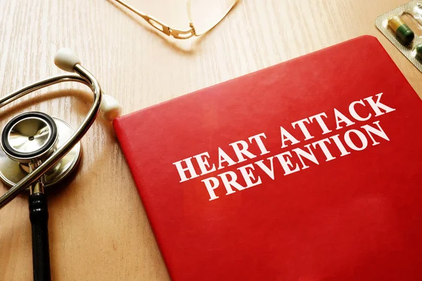 Livro de prevenção de ataque cardíaco em uma mesa . — Fotografia de Stock