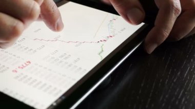 Hisse senedi verileri kontrol etmek için tablet kullanarak tüccar. Yakın çekim.