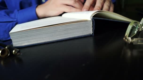 El hombre está abriendo un libro viejo y pasando páginas . — Vídeos de Stock