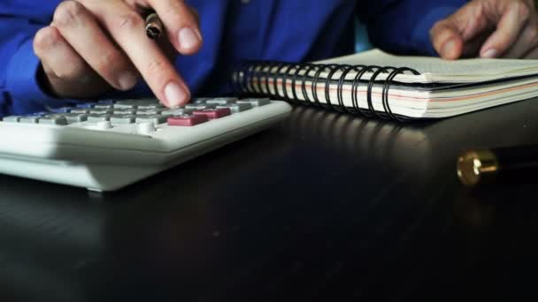 Accountant met behulp van de rekenmachine en het inchecken van een boekhouding boeken financiële cijfers. — Stockvideo