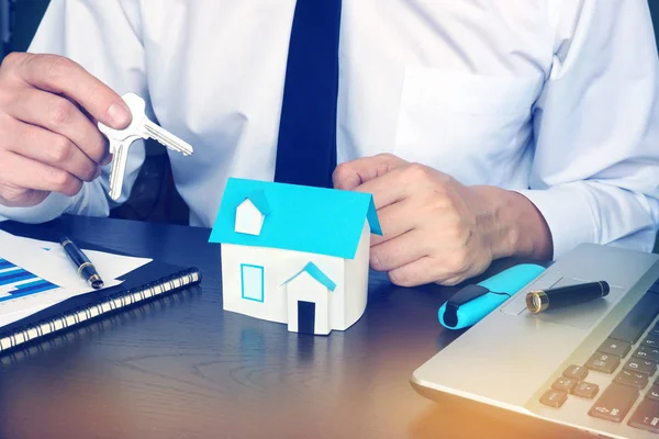 Hombre dando llaves de casa en una agencia inmobiliaria . —  Fotos de Stock