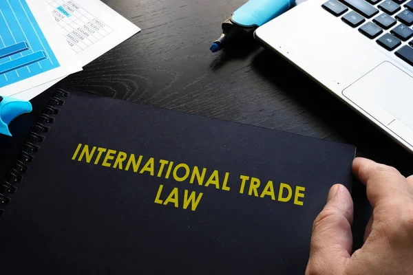Міжнародне торговельне право та блокнот на столі . — стокове фото
